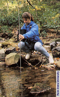 student assessing stream with instrument