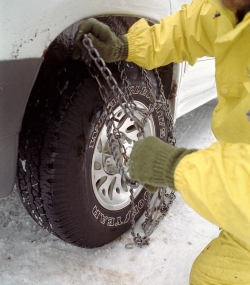 Picture of person putting on snow chains.