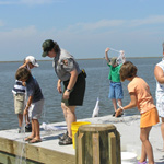 Visitors learn to throw a cast net at the Davis Bayou Pier in Ocean Springs, Mississippi.