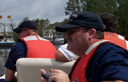Three men in life vests and blue uniforms.