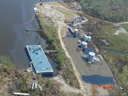 Aerial view of spilled oil and barge near shore.