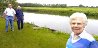 Betty Routh  (right) stands in her backyard in St. Joseph, which abuts former farmland that is being transformed into wetlands. Routh was joined by Bruce Stikkers, left, who helped put the project together, and Kenneth Kesler of the Champaign County Soil and Water Conservation (photo courtesy of Darrell Hoemman, Saint Joseph News Gazette)