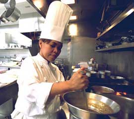 Photo:  Chef stiring a pot on the stove.