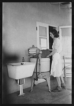 Arizona woman using electric washing machine, 1940.