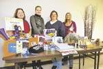 The Waukee PTO activities committee, from left, includes Patrice Thompson, Jenny Robinson, Julie Villines and Beth Gibbons. During a recent committee meeting, they displayed some of the donations they have collected for Winter Fun Night. DAVID K. PURDY/FOR THE REGISTER