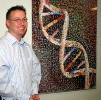 Geoff stands next to an image of a DNA molecule, which is often used to symbolize NHGRI’s genomic research.