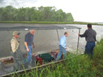 Chief Lancaster prepares to exit the front of a crawfish boat on the Durand Farm in south Louisiana after a first-hand look at a crawfish pond and crawfish harvest operation   (from left) Daniel Durand, landowner; Don Gohmert, NRCS State Conservationist; Chief Lancaster; and Gregory Durand, landowner.