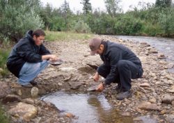 Father and son gold panning a creek.