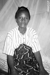 Photo of a woman sitting under a bednet to prevent malaria during pregnancy.