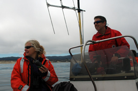 two biologists aboard a boat on a cloudy day