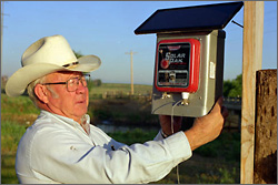 Photo of a rancher with a electric fence box,