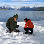 Picture of a Ranger and child snowshoeing.