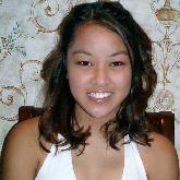 young woman wearing sleeveless blouse, sitting inside