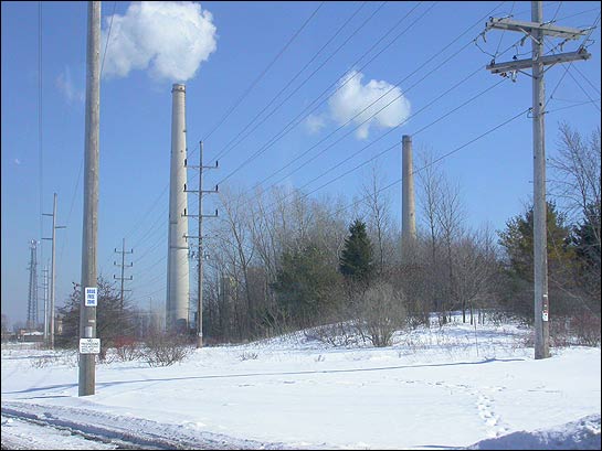 White smoke billows from two smoke stacks in winter scene