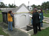 A group of workshop participants do a conditions assessment exercise on a small mausoleum. (Mary Striegel)