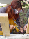 Lanie Swanson removes failed repair adhesive from a marble headstone. (Mary Striegel)