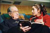 File photo from Administration on Aging depicting a young woman discussing what a senior man is reading.