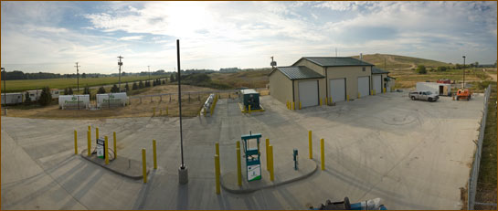 Large open lot by landfill with two gas pumps