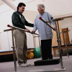 Photograph of a male physical therapist working with an elderly woman