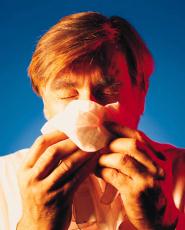 Photograph of a man blowing his nose