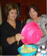 Promotora Lourdes Fernandez, right, assists a participant during a Diabetes and the Family class.
