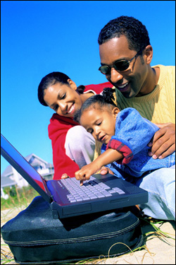 Foto: una familia reunida alrededor de una computadora portátil.