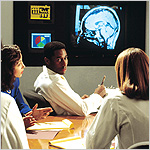 medical professionals sitting at a table viewing a brain scan