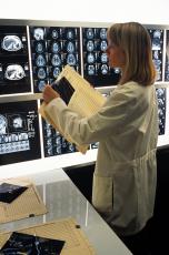 Photograph of a female health professional looking at brain images