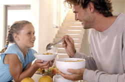 man and girl eating cereal