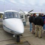 photo of front of plane with a group of people standing nearby