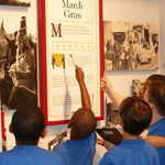 Boys in school uniforms look at an exhibit panel at the Acadian Cultural Center in Lafayette