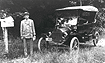 Rural letter carrier with his automobile next to a mailbox