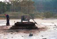 Researcher assessing the condition of a detonator transport container following a burn at the Explosives Testing Plateau
