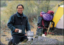 Photo: A man making coffee at a camp site