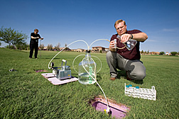 In Pacana Park, soil scientist draws water samples from large lysimeters installed under the turf while microbiologist collects soil samples to assess downward bacterial transport from the surface: Click here for full photo caption.