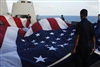 U.S. Navy sailors fold a 30-foot by 60-foot American flag.