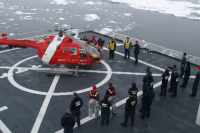 Canadian Helicopter on U.S. Coast Guard Cutter Healy: U.S. Coast Guard members waiting to greet visitors from the Candian Coast Guard ship Louis S. St. Laurent. The helicopter is on U.S. Coast Guard Cutter Healy in the Arctic Ocean. (Arctic)