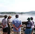Park ranger talks with visitors with island in background.