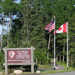 American and Canadian flags fly next to Saint Croix entrance sign.