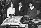 Harry Ransom examining collection materials with two students.