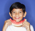 [PHOTOGRAPH] A smiling kid eating watermelon