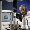 Mechanical engineer Herb Bandy uses a CMM to measure the dimensions of a cylinder-shaped machined part.