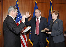 Bob Howard (center) is sworn in by Secretary as wife Ciretta Howard (right) holds the family Bible.