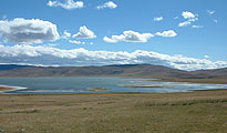 Mongolia’s Erhel Lake, surrounded by green, rolling countryside.