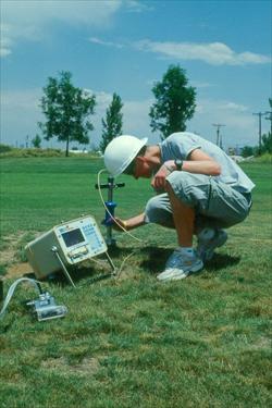 : Student volunteer measuring soil moisture & greenhouse gases. (Englewood, CO, USA)
