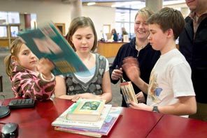 The Hogenson family — from left, Devon, Bryn and Matthew and their mother, Stephanie, in back — check out the Bellevue Regional Library on Wednesday. 