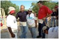 President Bush and Secretary for Housing and Urban Development Martinez, right, talk with new friends during a break from their house-building efforts at the Waco, Texas, location of Habitat for Humanity's "World Leaders Build" construction drive August 8, 2001. 