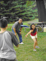 Dad and two kids playing frisbee