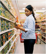 Woman looking at canned goods in a grocery store