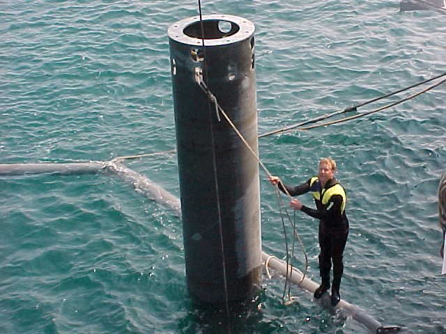 Two photos of spar deploy and divers on offshore net.